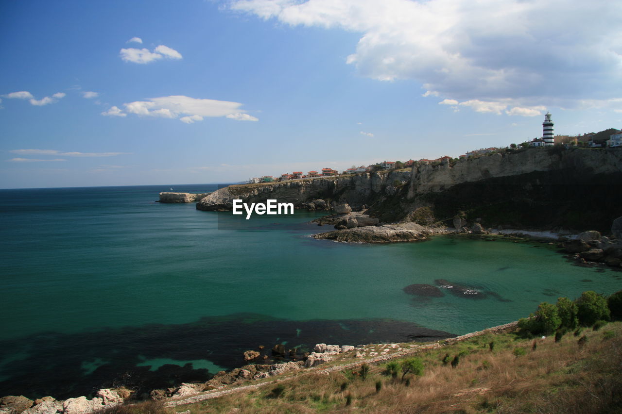 Scenic view of cliff by sea against sky