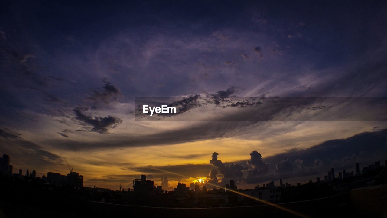 SILHOUETTE BUILDINGS AGAINST CLOUDY SKY DURING SUNSET