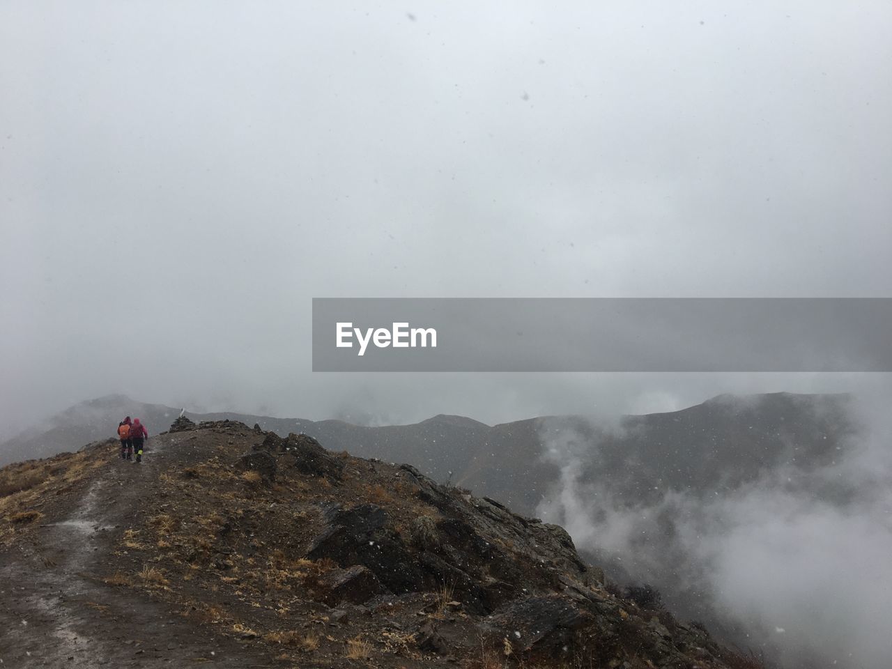 PERSON WALKING ON MOUNTAIN AGAINST SKY