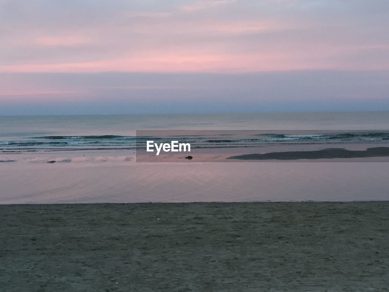 SCENIC VIEW OF BEACH AGAINST SKY AT SUNSET