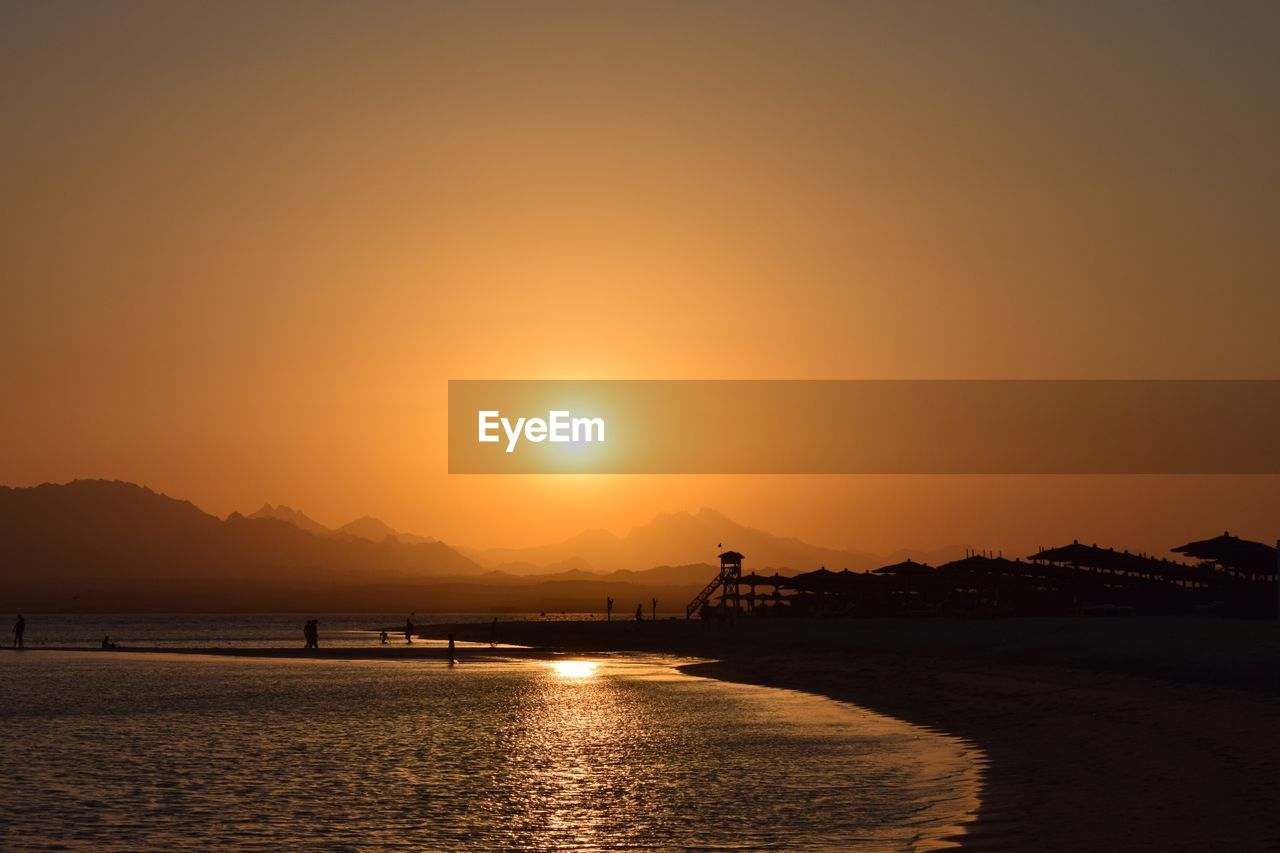 Scenic view of sea against orange sky