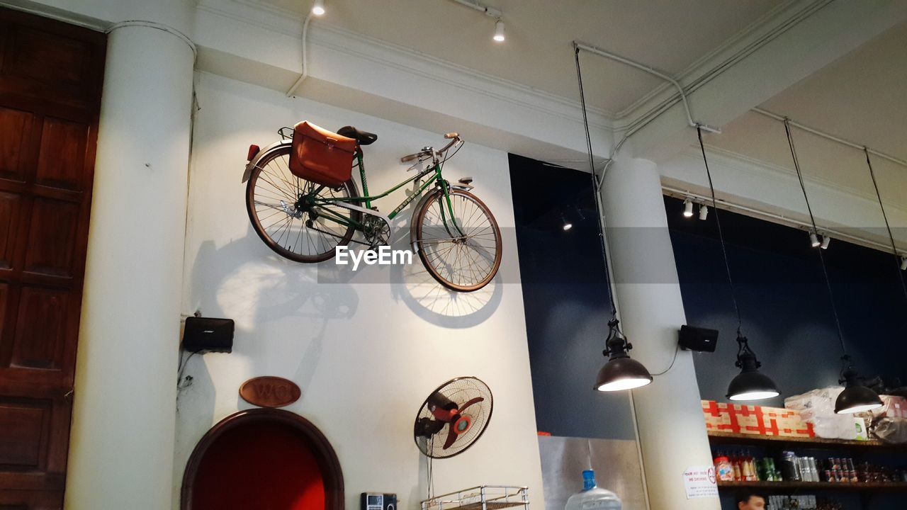 LOW ANGLE VIEW OF BICYCLE HANGING ON STORE