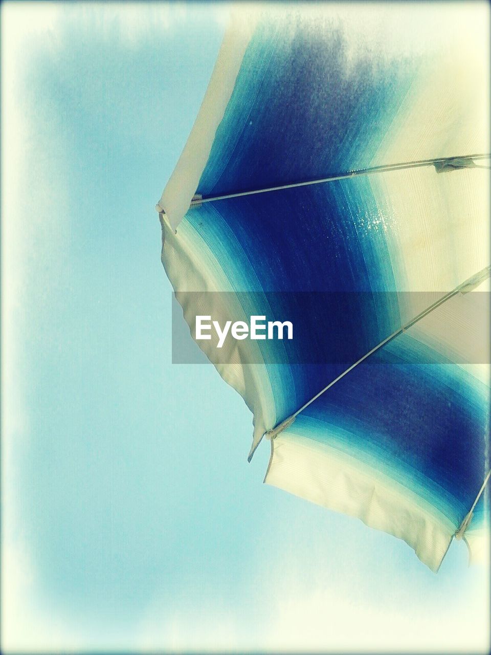 Cropped parasol against blue sky
