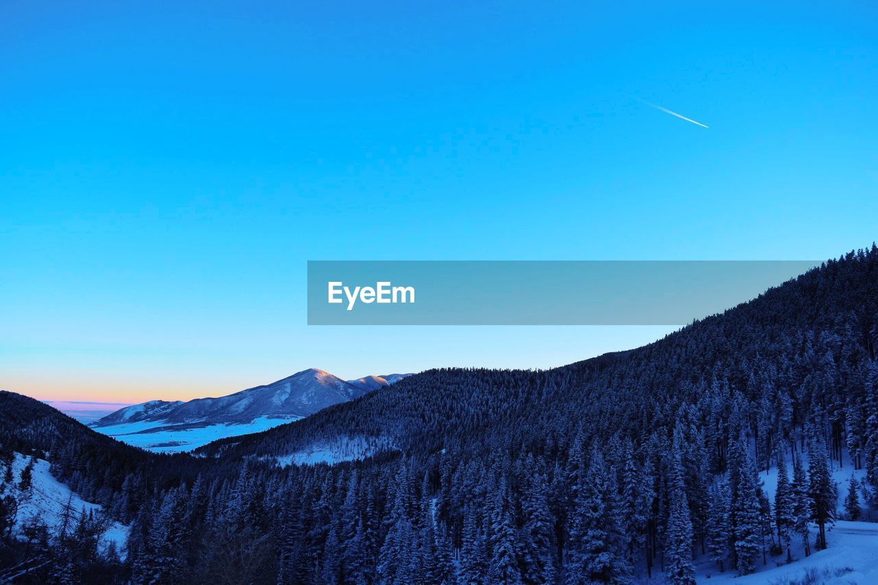SCENIC VIEW OF SNOWCAPPED MOUNTAINS AGAINST BLUE SKY