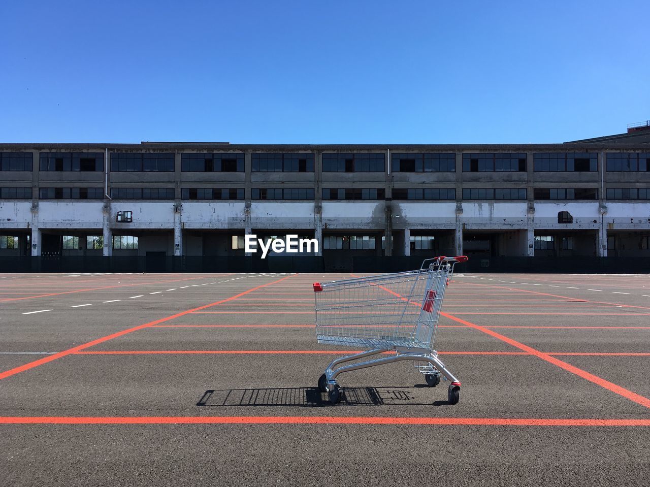 View of shopping cart on road against blue sky