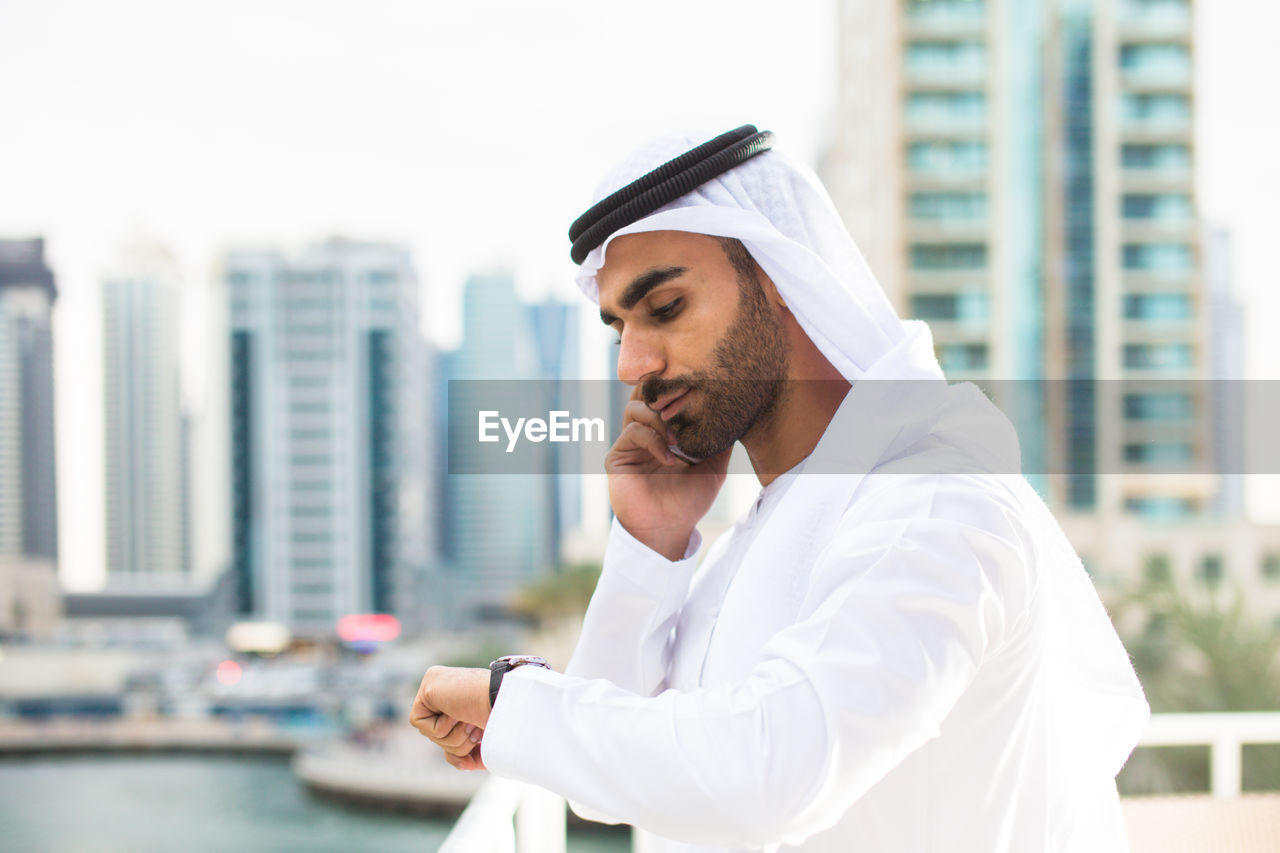 Young man wearing traditional clothing talking over smart phone