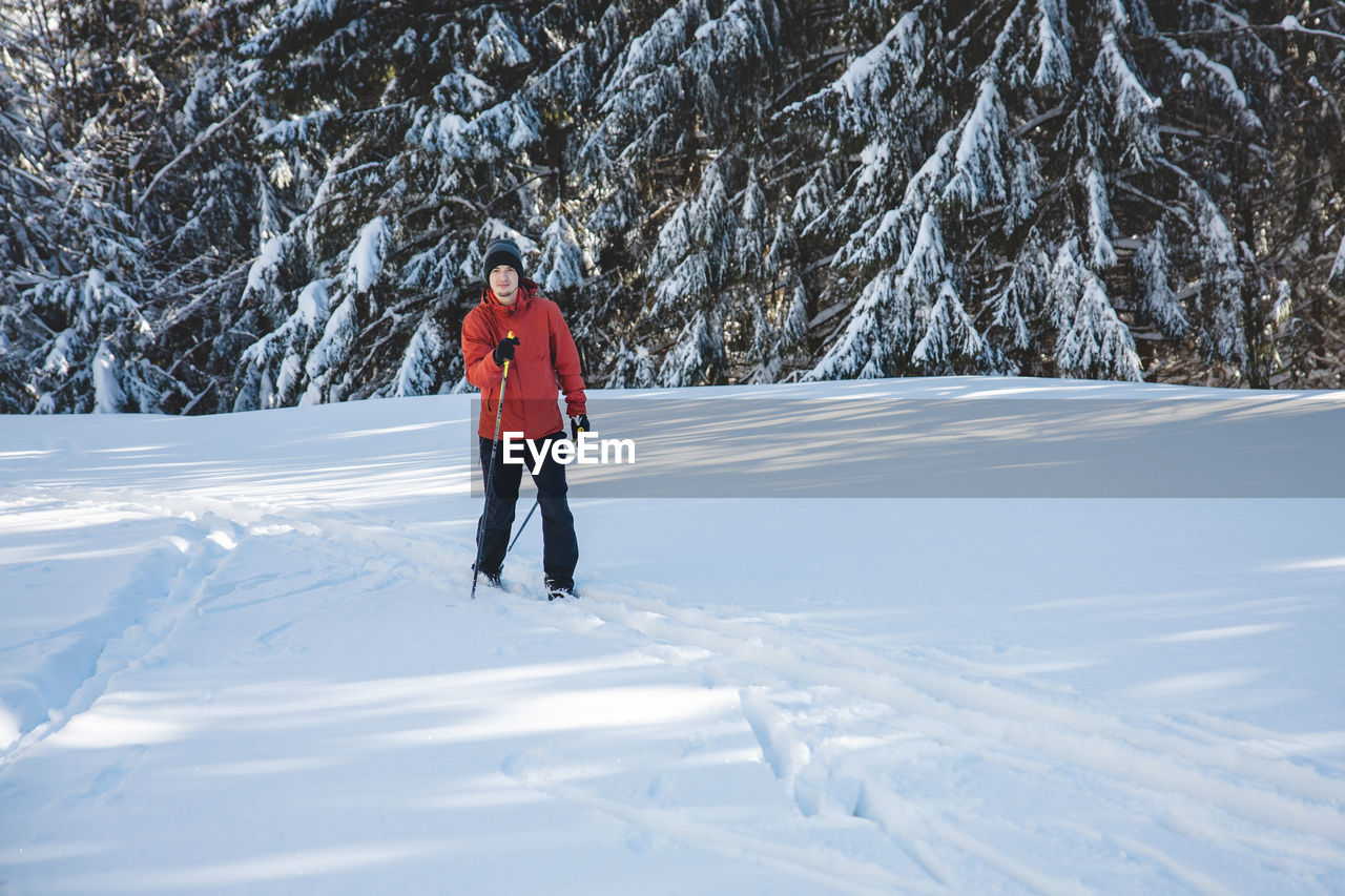 full length of man skiing on snow covered field
