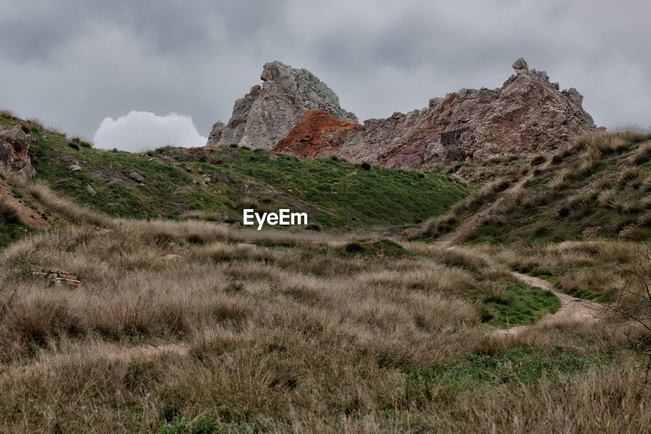 Scenic view of land and mountains against sky