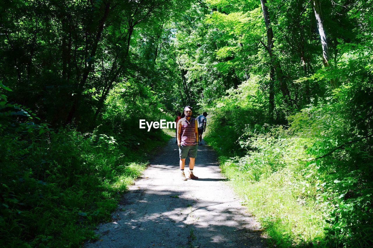 WOMAN WALKING ON FOOTPATH IN FOREST