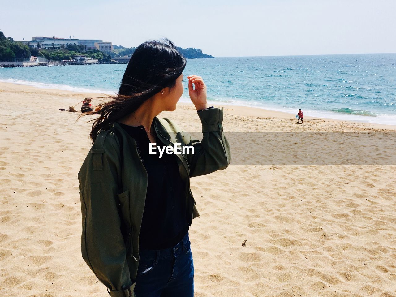 Rear view of woman photographing on beach