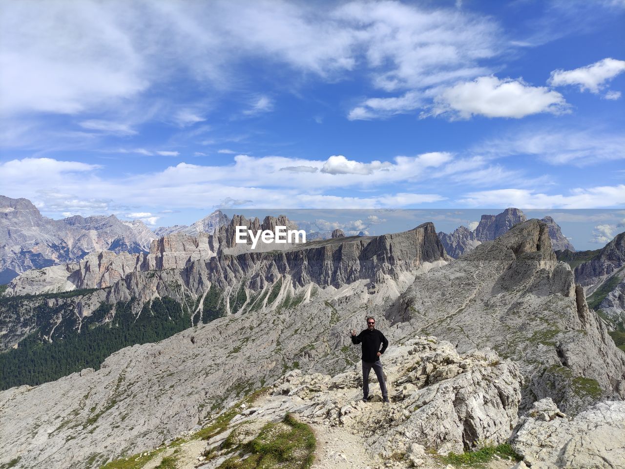 Rear view of man walking on mountain against sky