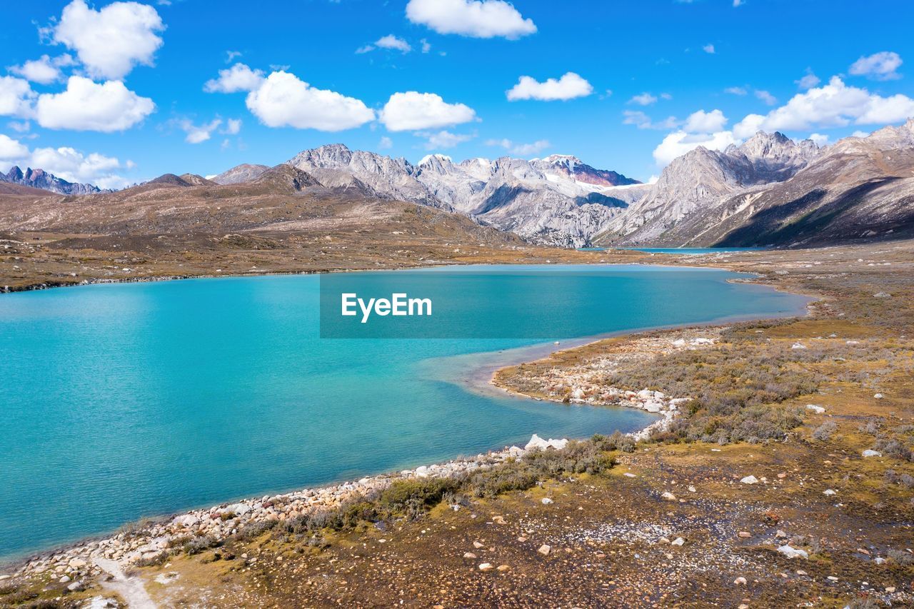 mountain, water, scenics - nature, environment, landscape, beauty in nature, sky, mountain range, nature, lake, land, snow, travel destinations, travel, cloud, blue, cold temperature, tranquil scene, tranquility, crater lake, no people, mountain peak, body of water, reservoir, snowcapped mountain, winter, tourism, day, outdoors, non-urban scene, wilderness, turquoise colored, lagoon, glacial lake, idyllic, beach, reflection, vacation, trip
