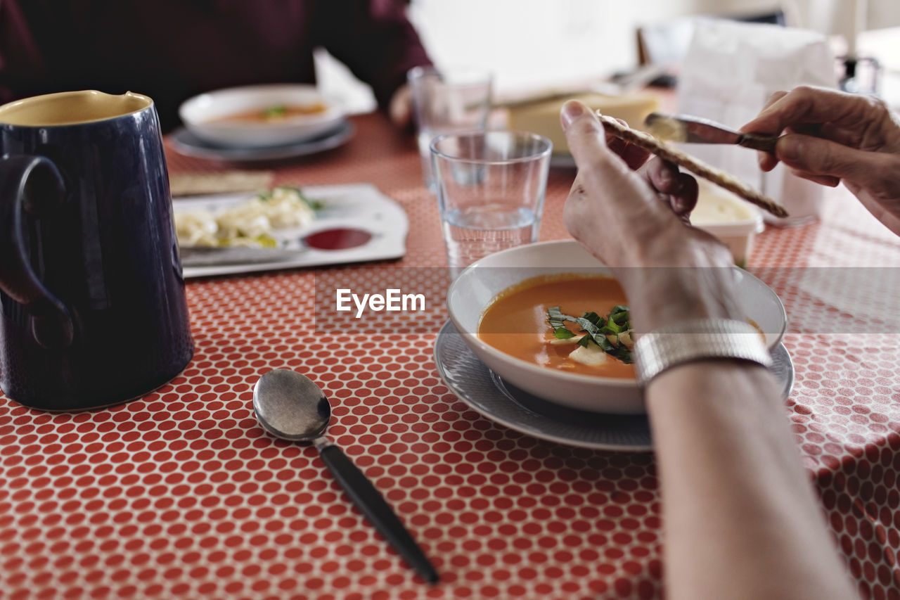 Cropped image of senior couple sitting with food at dining table