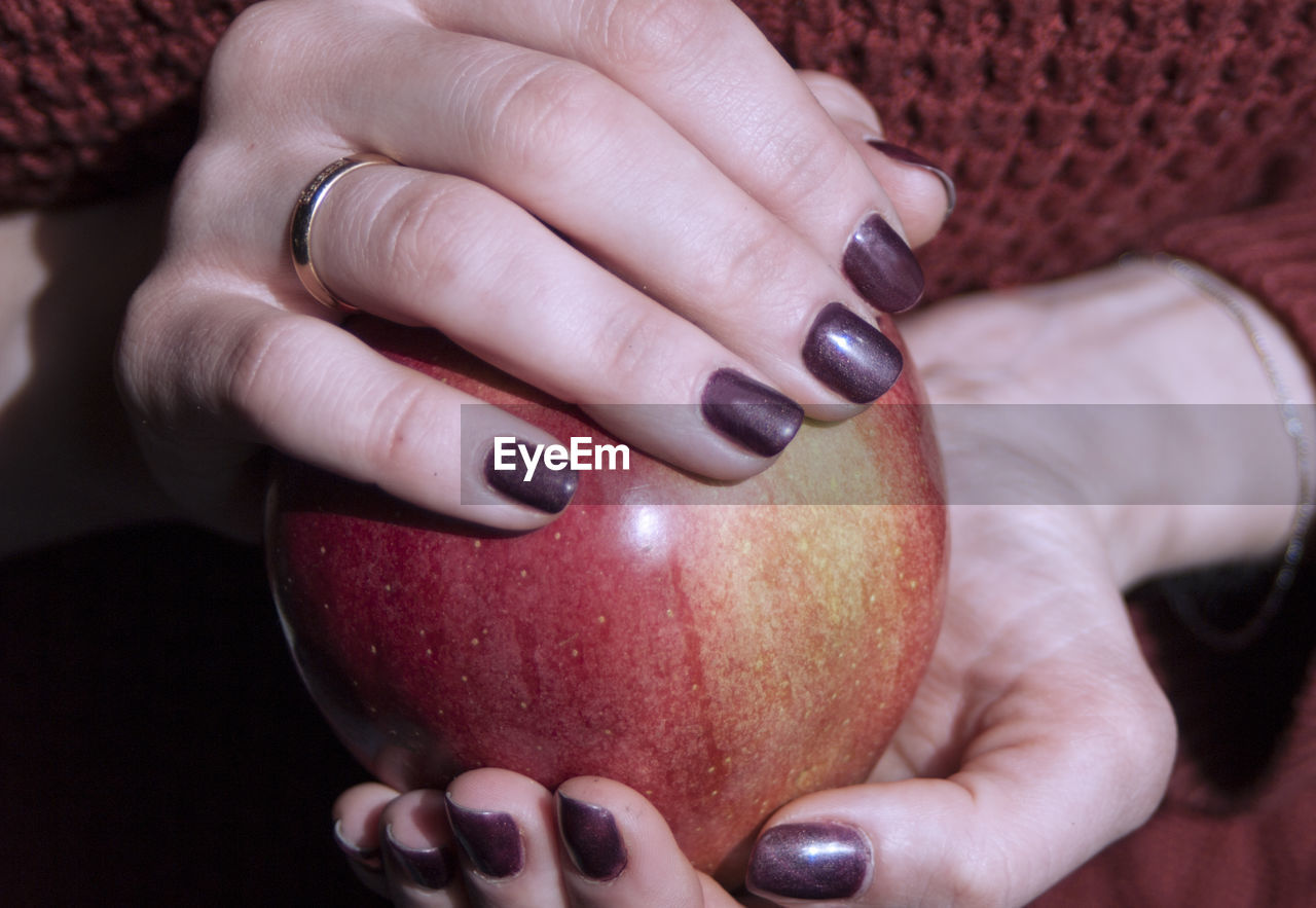 MIDSECTION OF WOMAN HOLDING RED APPLE