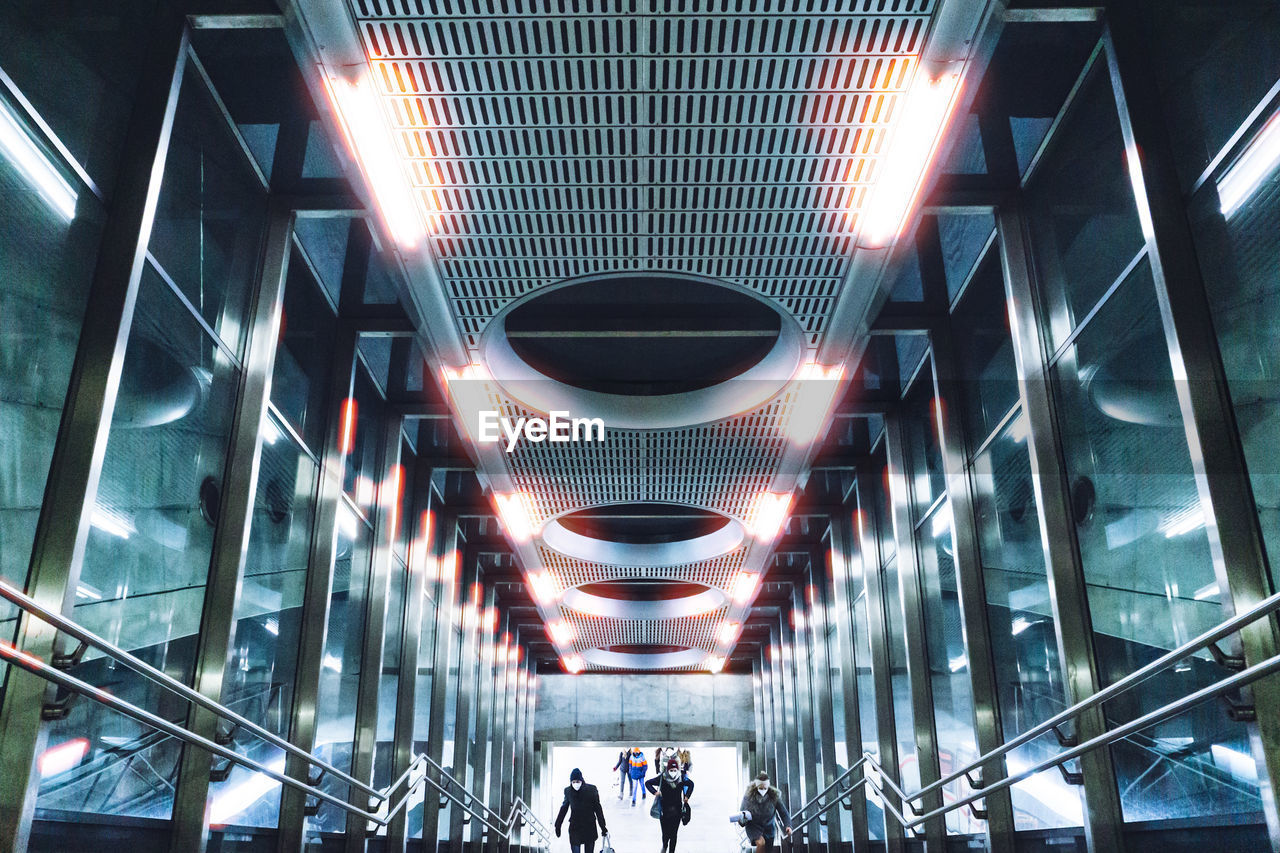 LOW ANGLE VIEW OF PEOPLE WALKING ON MODERN BUILDING