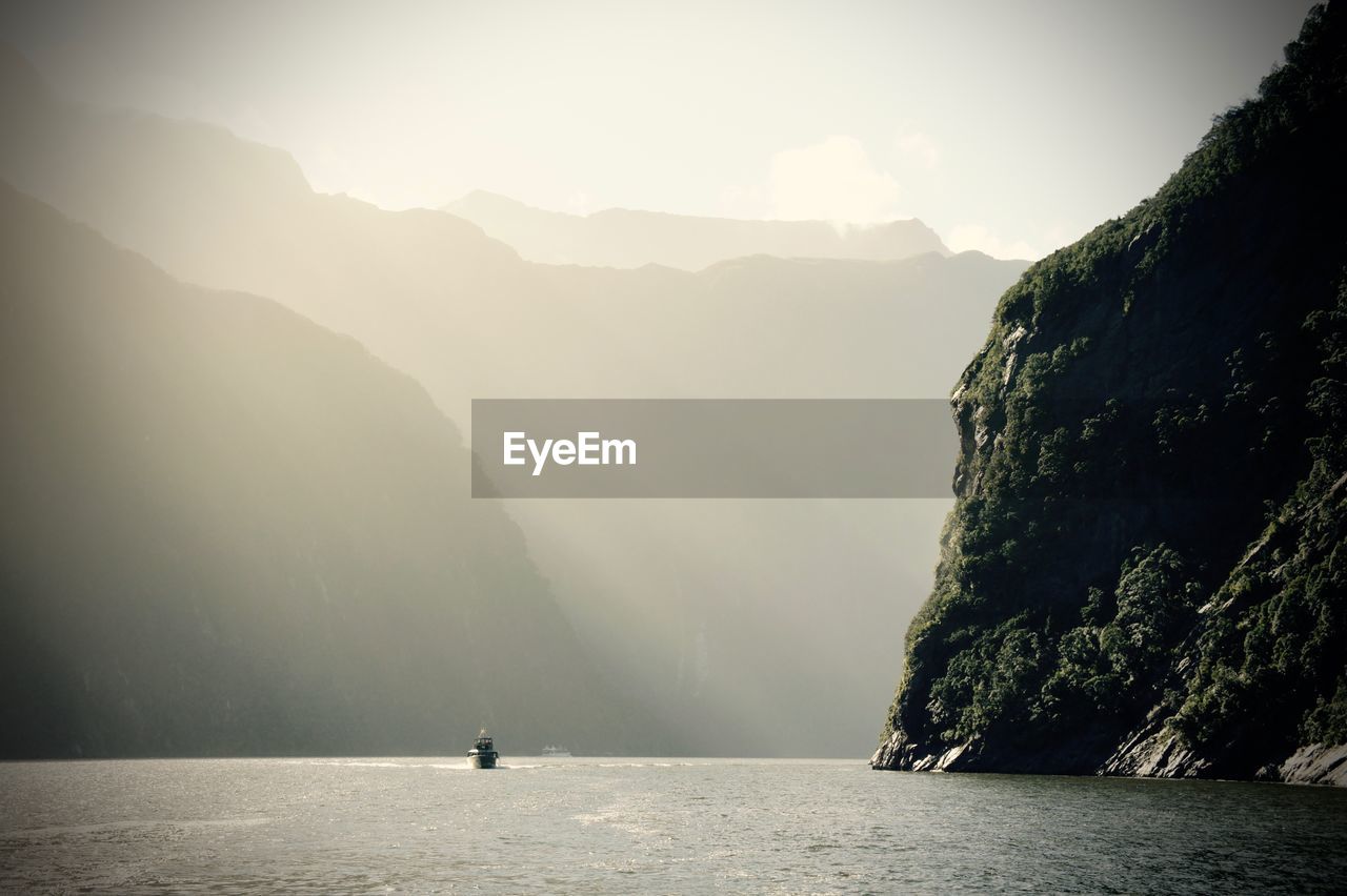 Scenic view of milford sound by mountains against sky