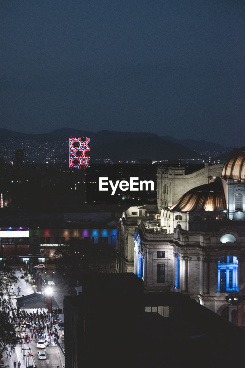 ILLUMINATED CITYSCAPE AGAINST CLEAR SKY