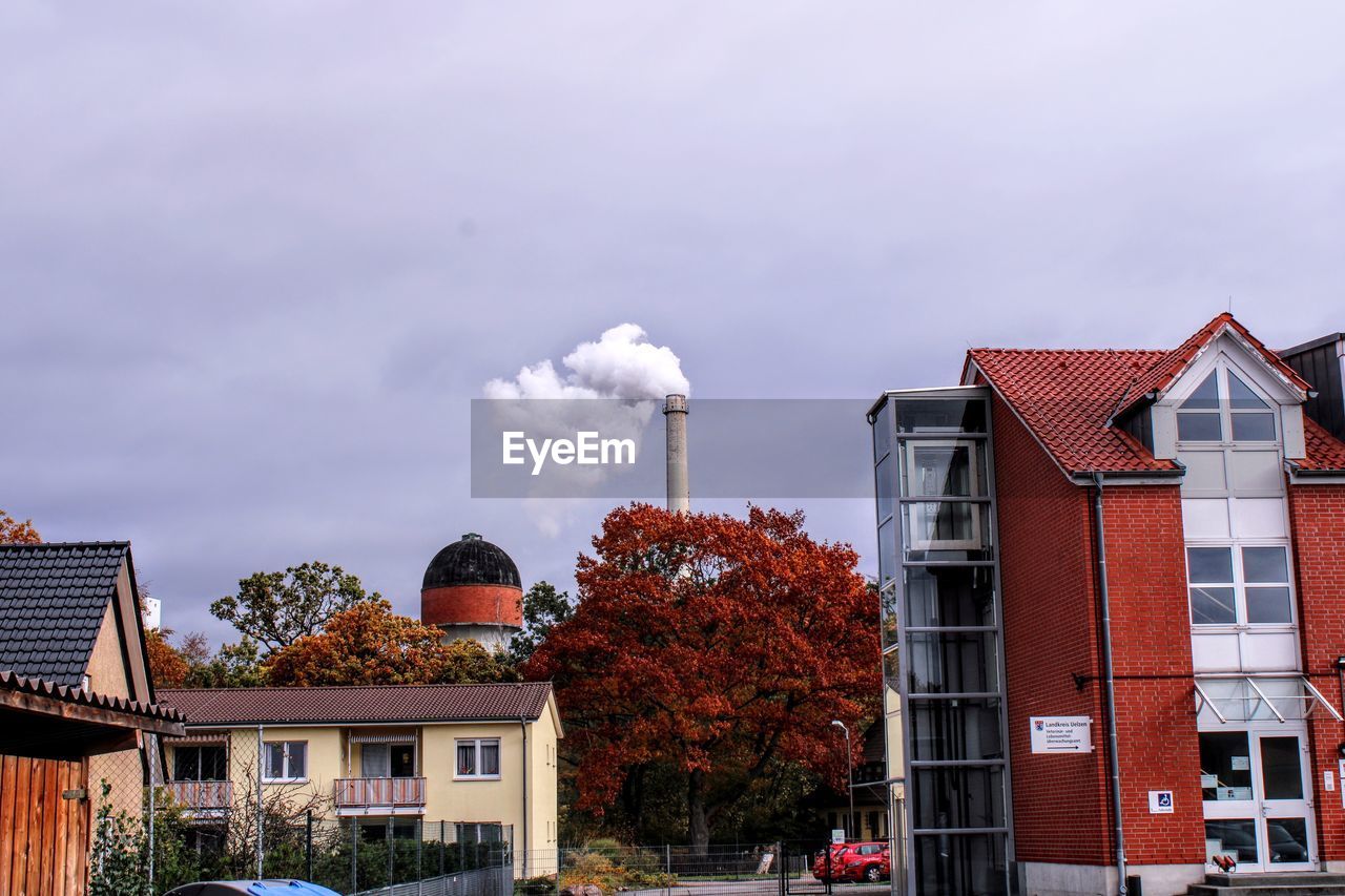 SMOKE EMITTING FROM CHIMNEY AGAINST BUILDINGS