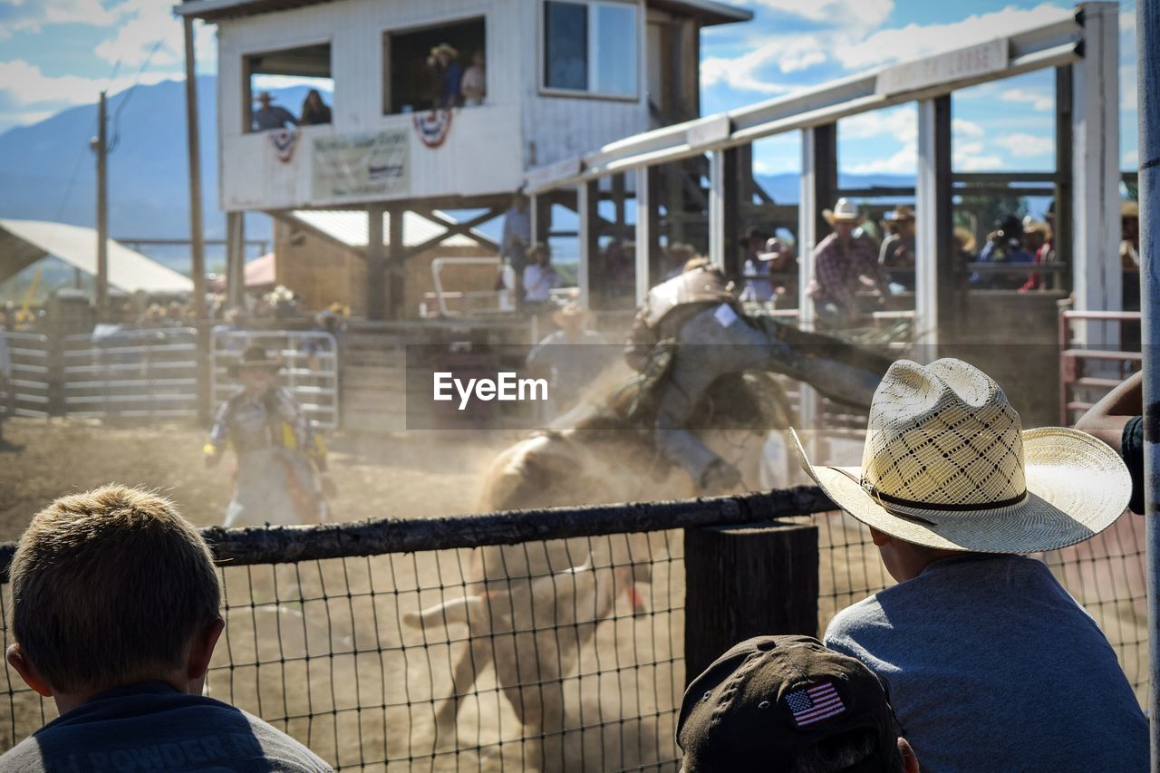 Cowboys looking at rodeo bullfighters during competition