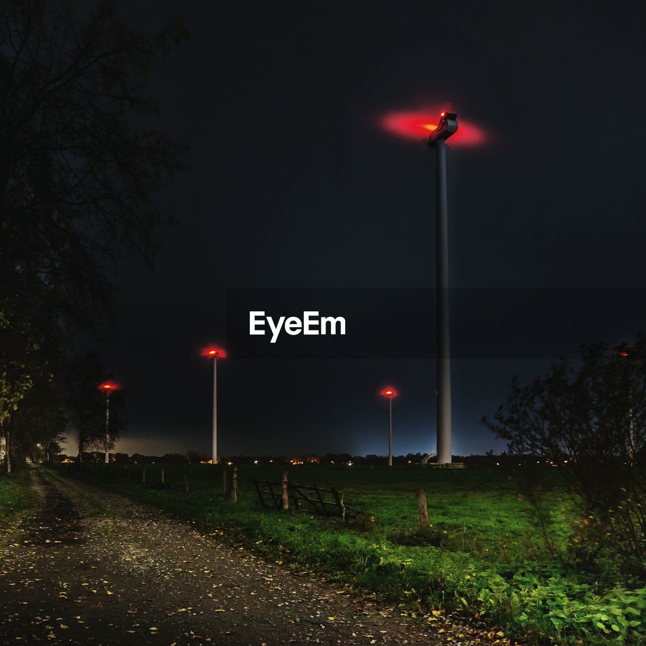 Footpath by illuminated street lights at night