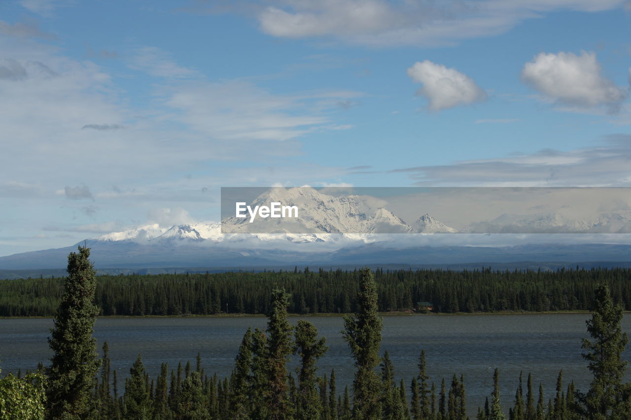 Scenic view of lake by mountains against sky