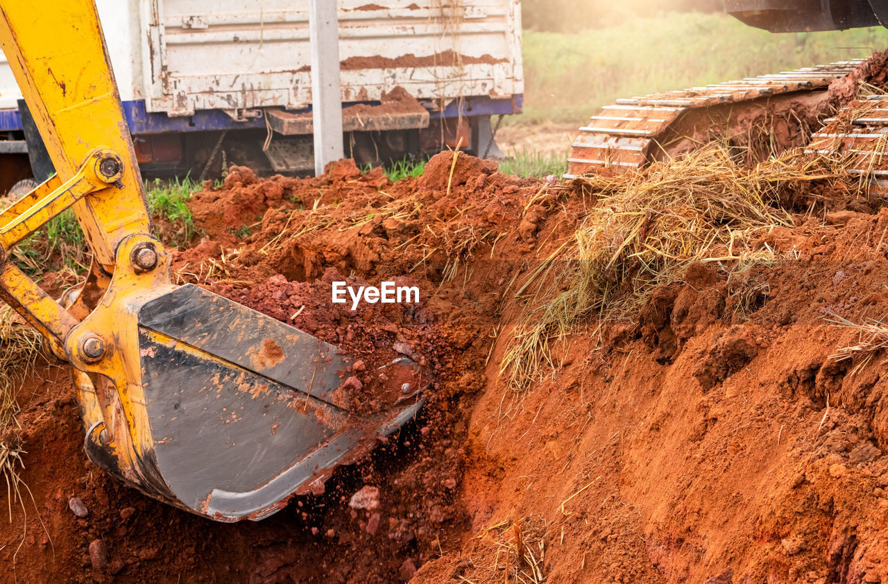 Excavator bucket digging soil for loading to truck. earthwork. dirt metal bucket of backhoe working