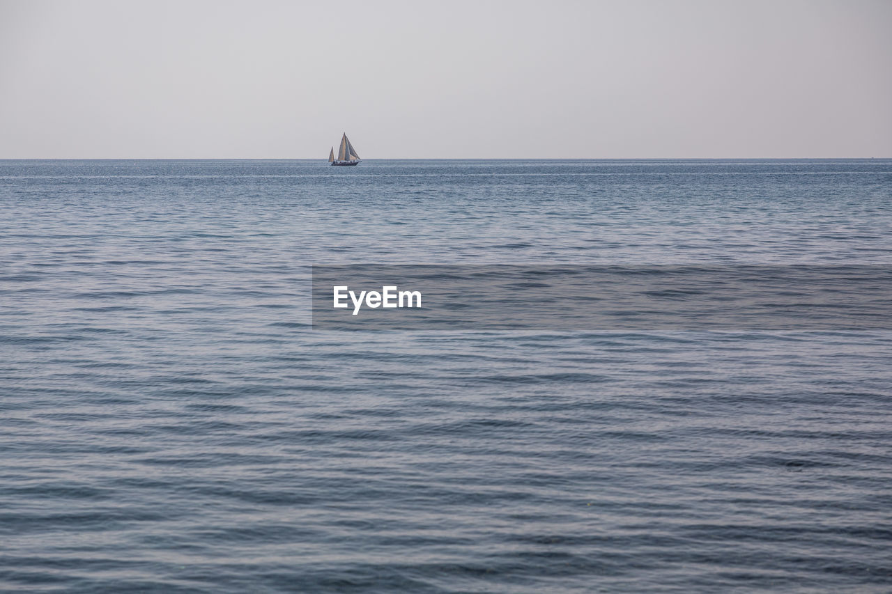 Sailboat sailing on sea against clear sky