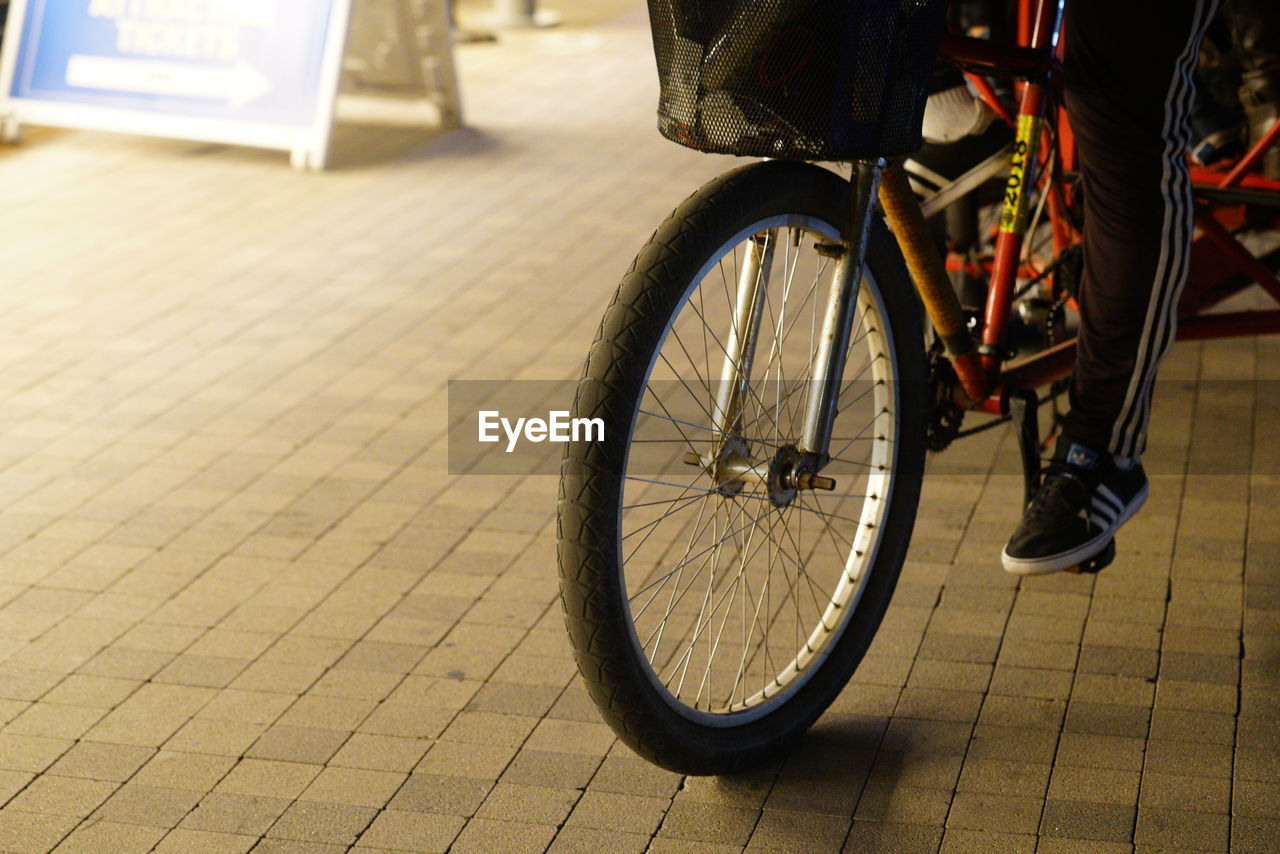 LOW SECTION OF MAN WITH BICYCLE ON TILED FLOOR