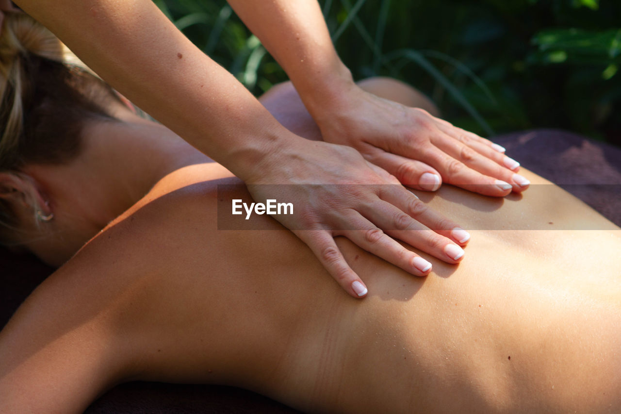 Cropped hands giving back massage to woman