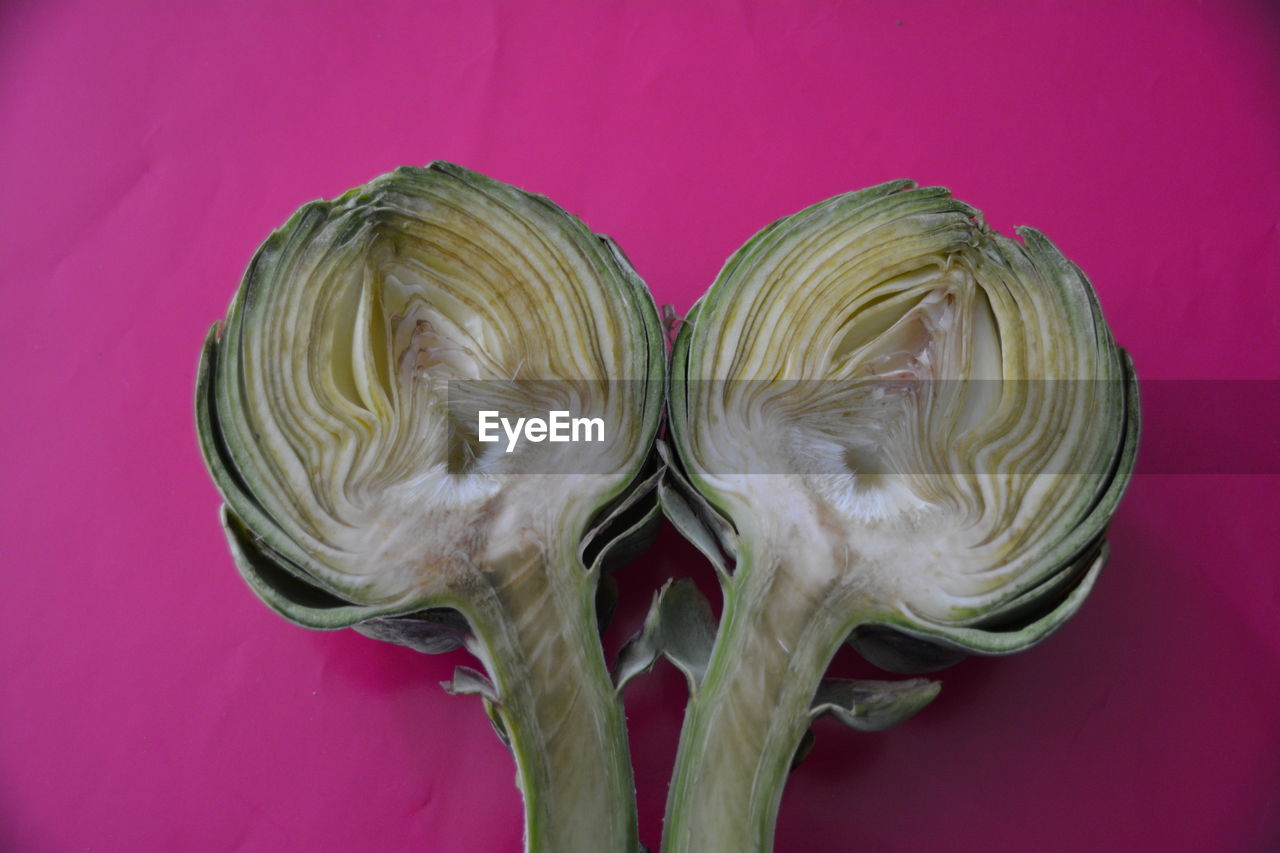 Close-up of sliced artichoke on pink background