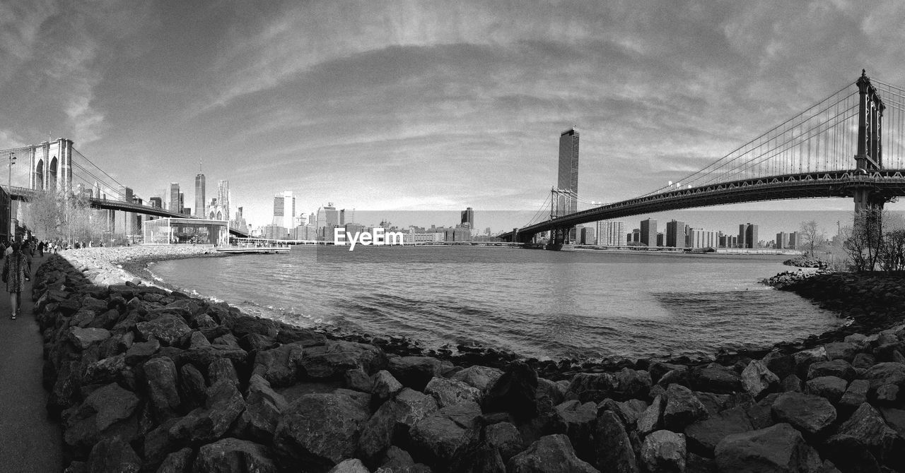 architecture, built structure, bridge, black and white, sky, water, city, transportation, monochrome photography, travel destinations, nature, monochrome, cloud, building exterior, suspension bridge, engineering, river, cityscape, panoramic, travel, tourism, landscape, outdoors, urban skyline, building, skyscraper, city life, rock