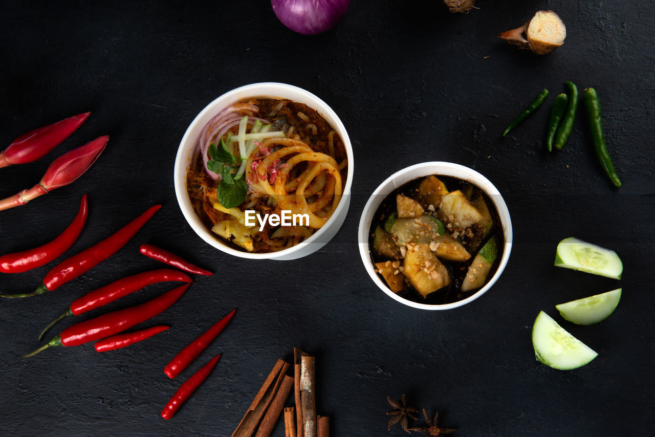 HIGH ANGLE VIEW OF NOODLES AND VEGETABLES IN BOWL ON TABLE