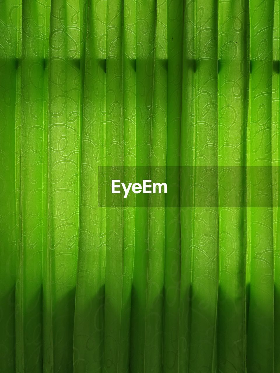 Close up of green curtain with little backlight