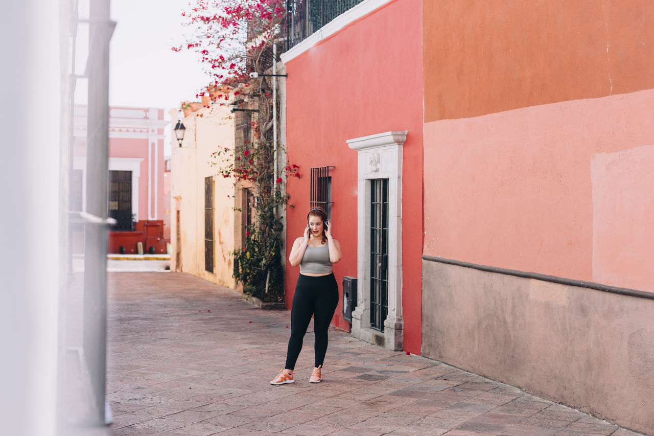 Woman standing amidst buildings in city