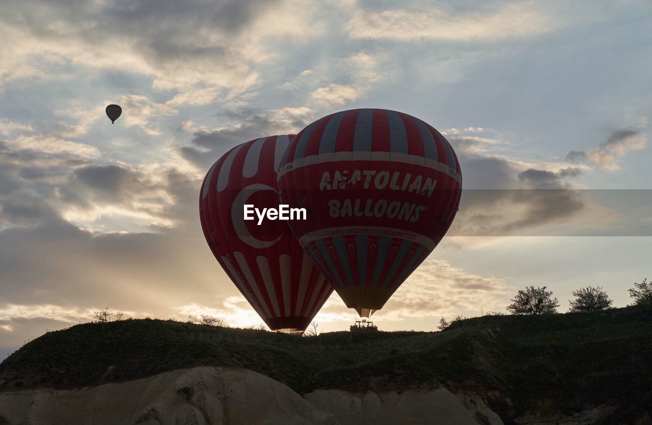 LOW ANGLE VIEW OF HOT AIR BALLOON AGAINST SKY AT SUNSET