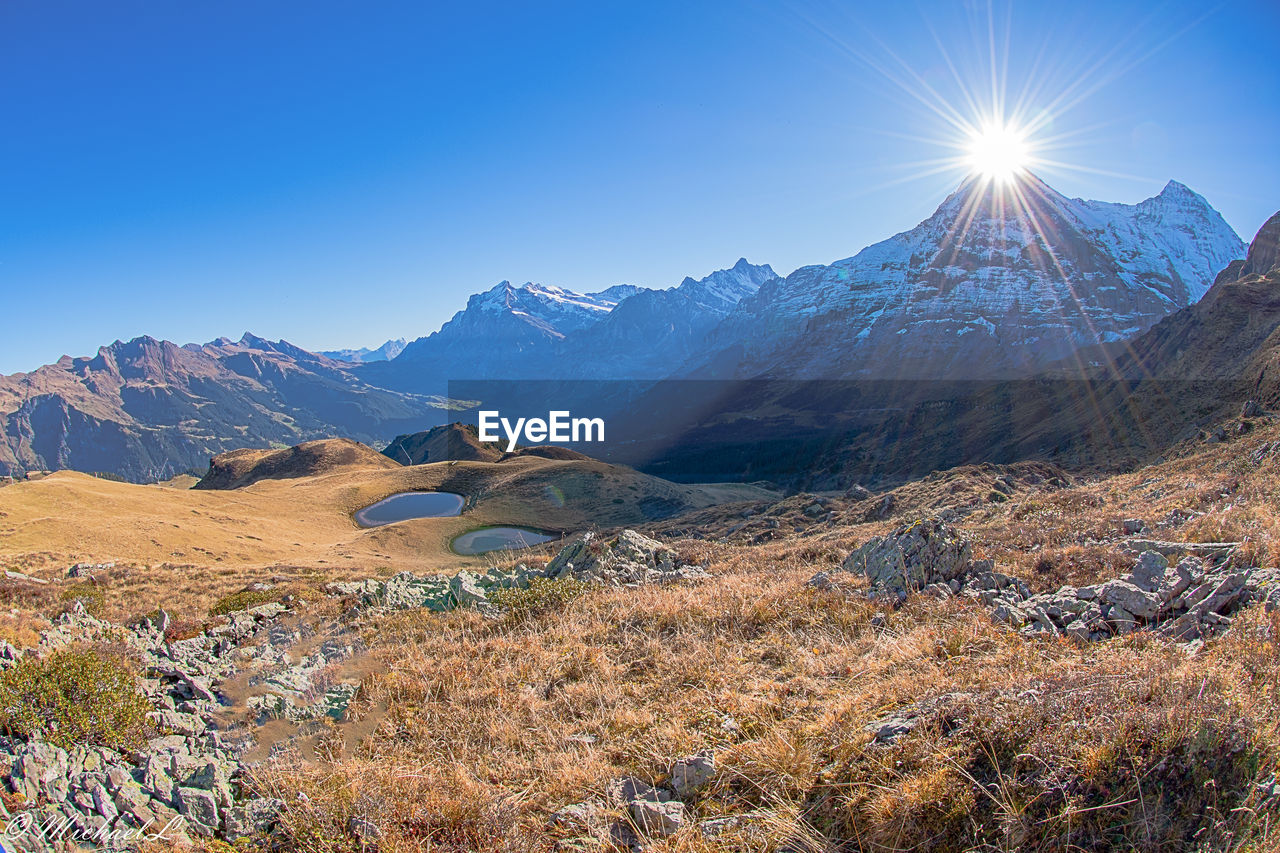 SCENIC VIEW OF SNOWCAPPED MOUNTAINS AGAINST BRIGHT SKY