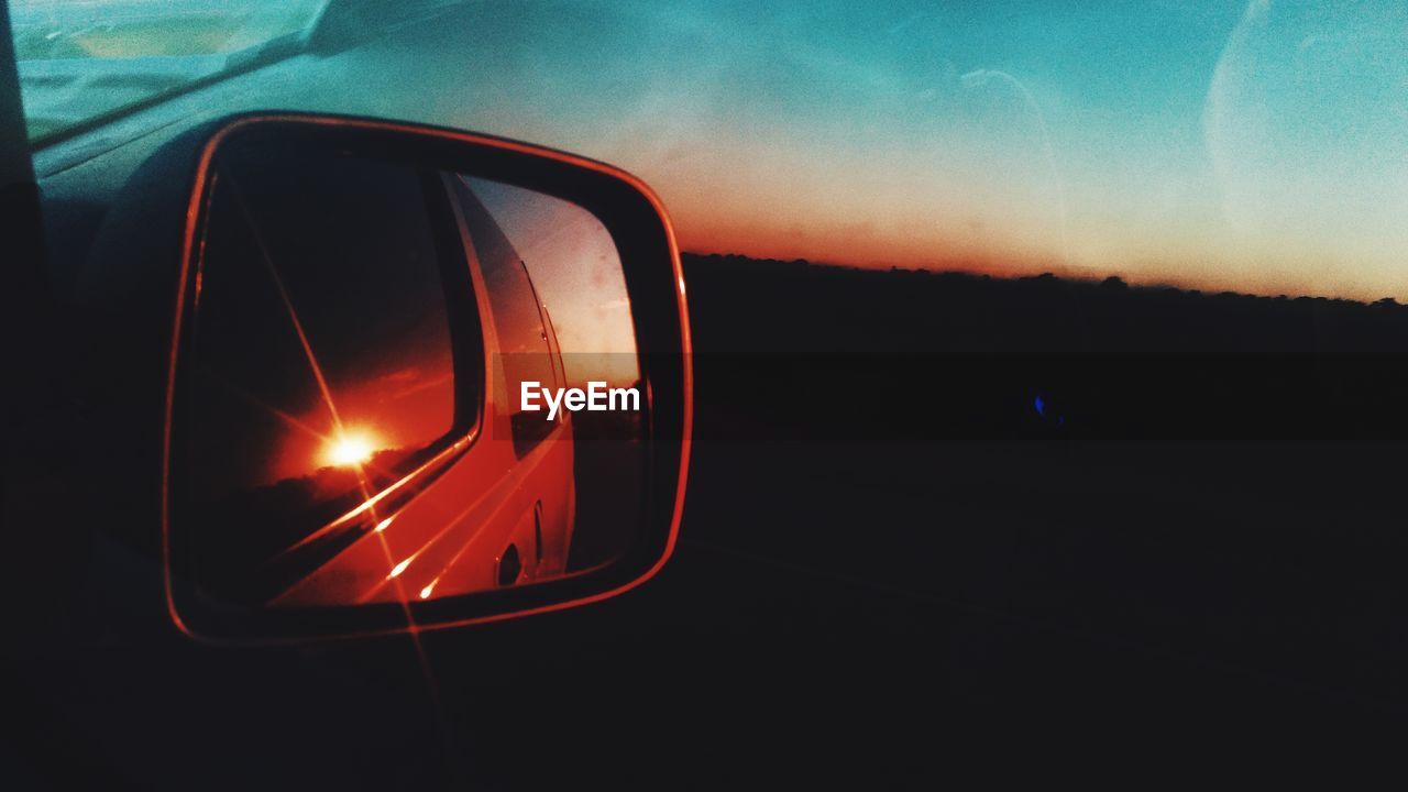 CLOSE-UP OF CAR SIDE-VIEW MIRROR