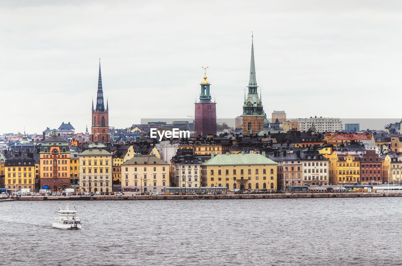 Cityscape by lake against clear sky