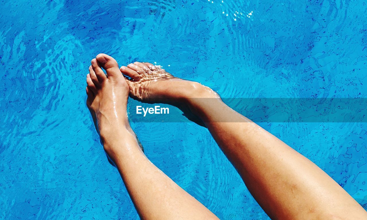 Low section of woman swimming in pool