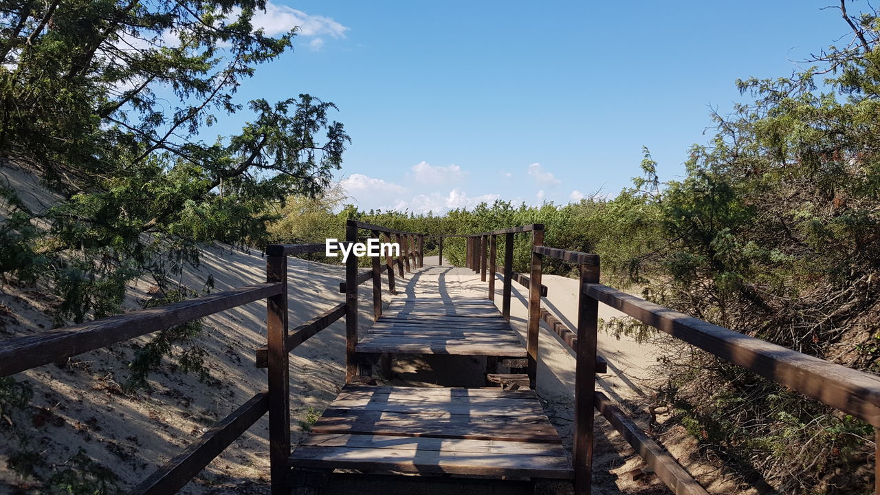 WOODEN FOOTBRIDGE AGAINST SKY