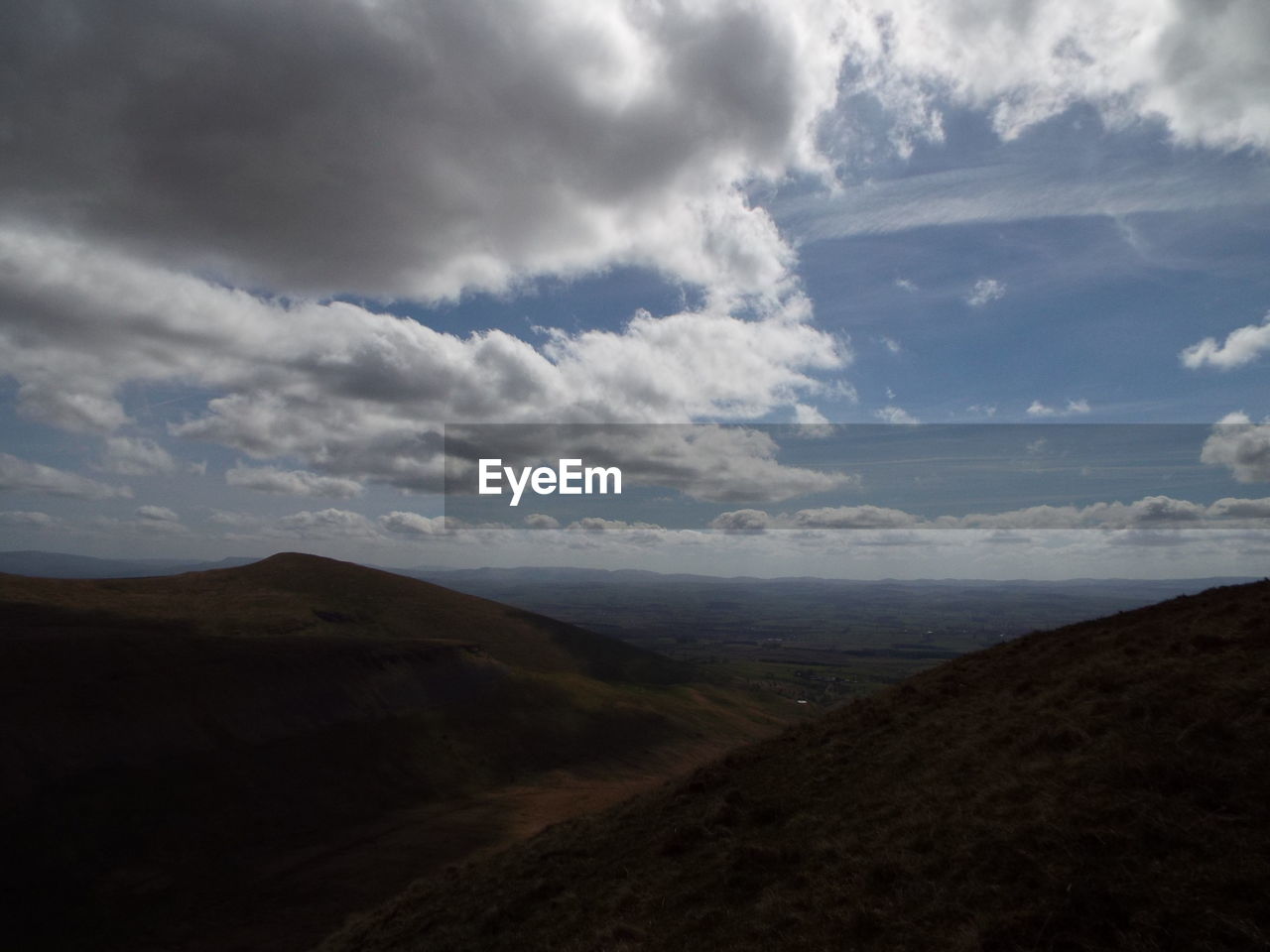 Scenic view of mountains against cloudy sky