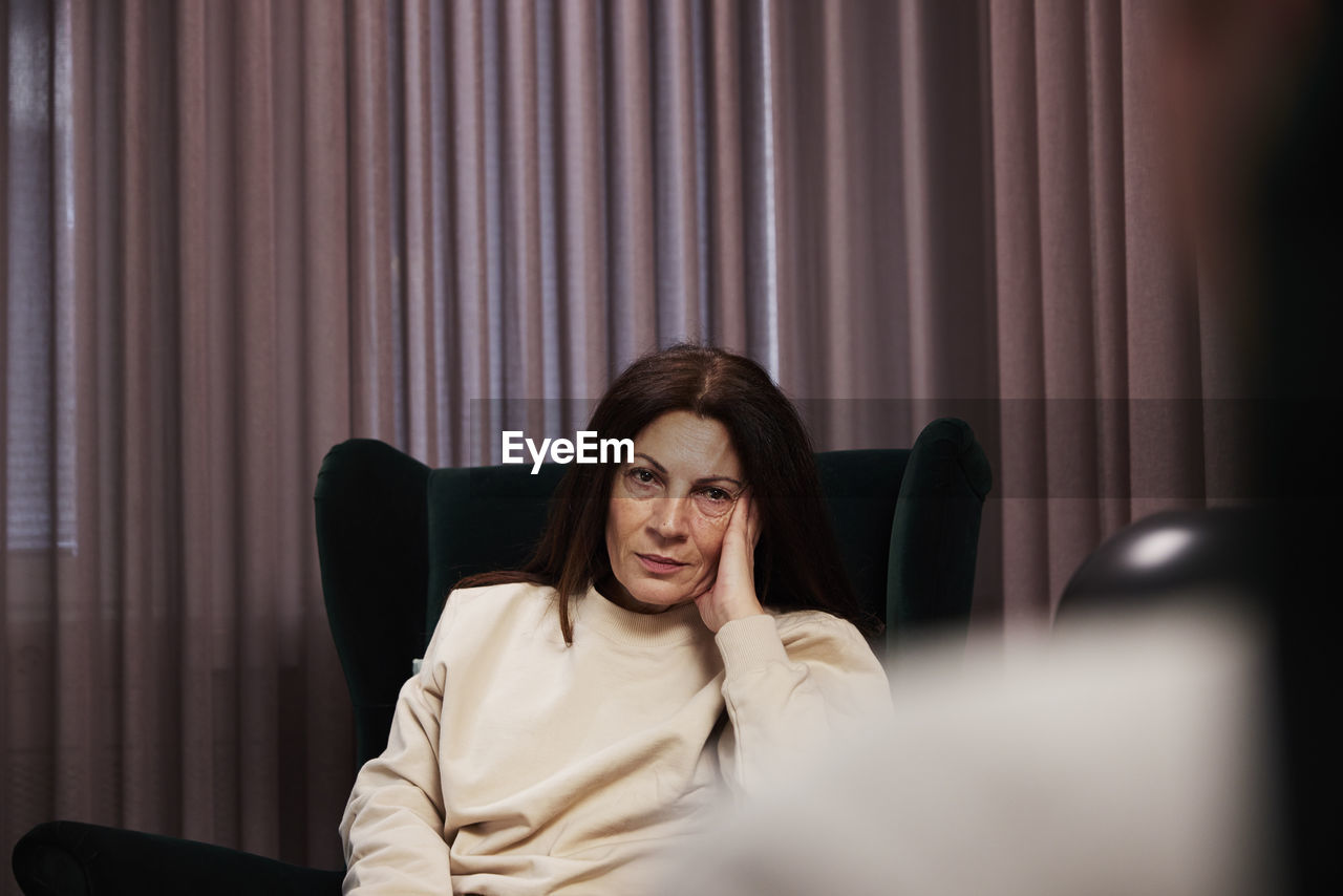 Female patient sitting in armchair at therapy session