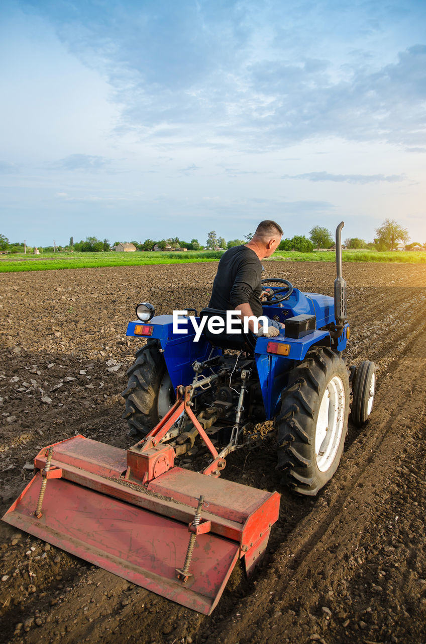 A farmer is cultivating a field before replanting seedlings. milling soil. softening the soil