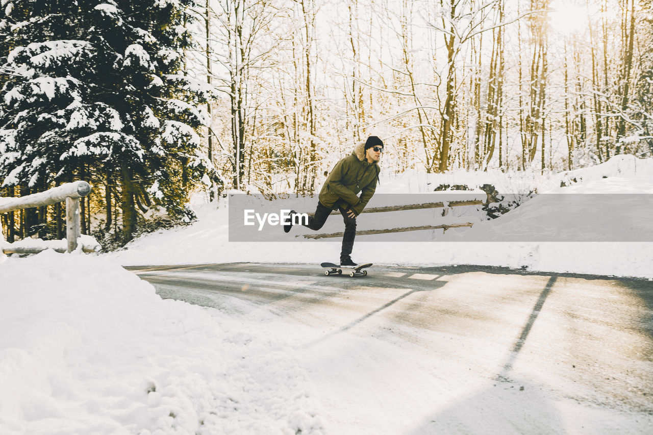 Full length of man skateboarding in snow