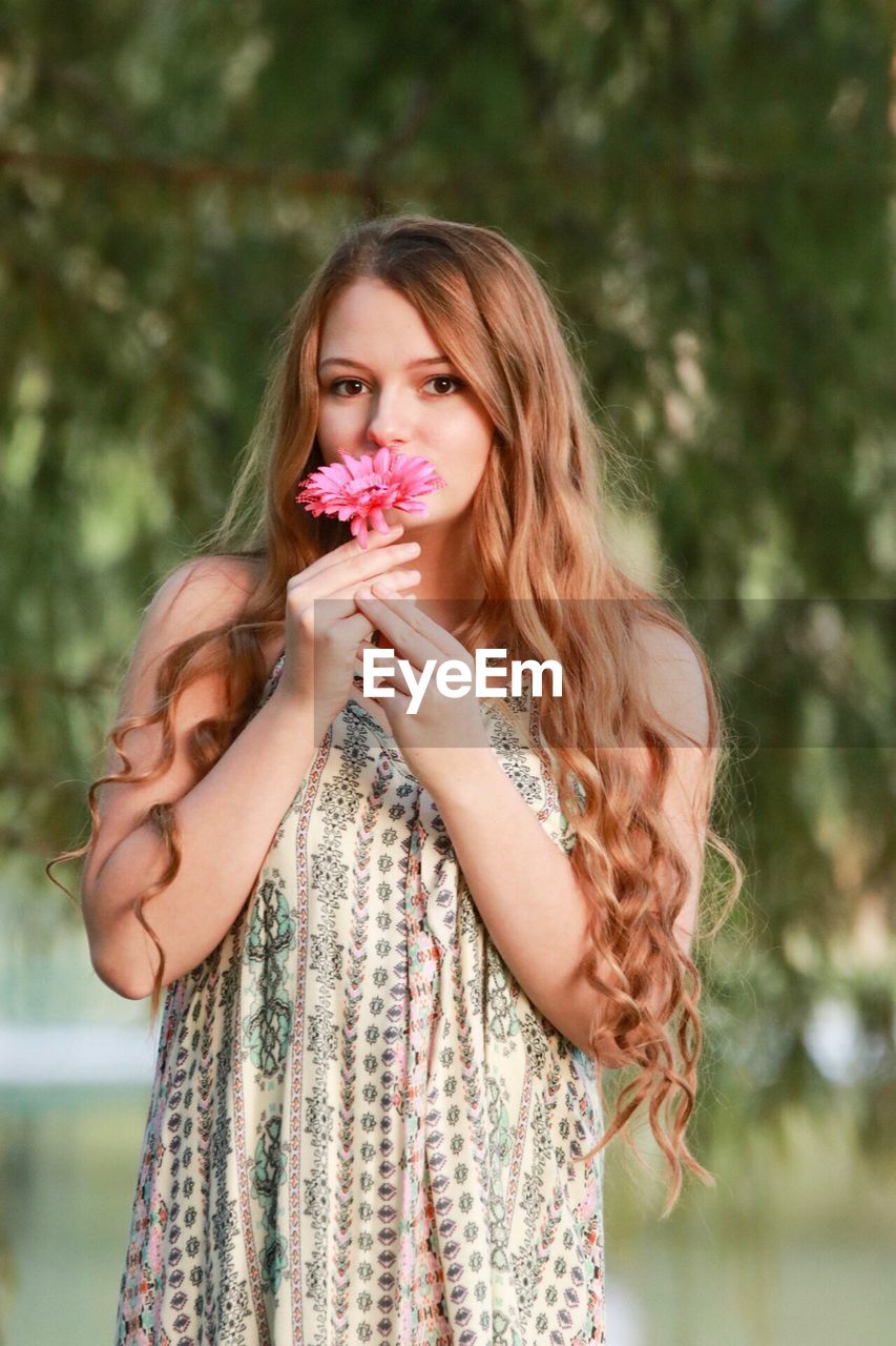 Portrait of beautiful woman holding flower