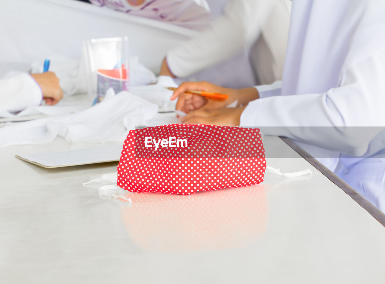MIDSECTION OF WOMAN WORKING ON TABLE WITH PAPER
