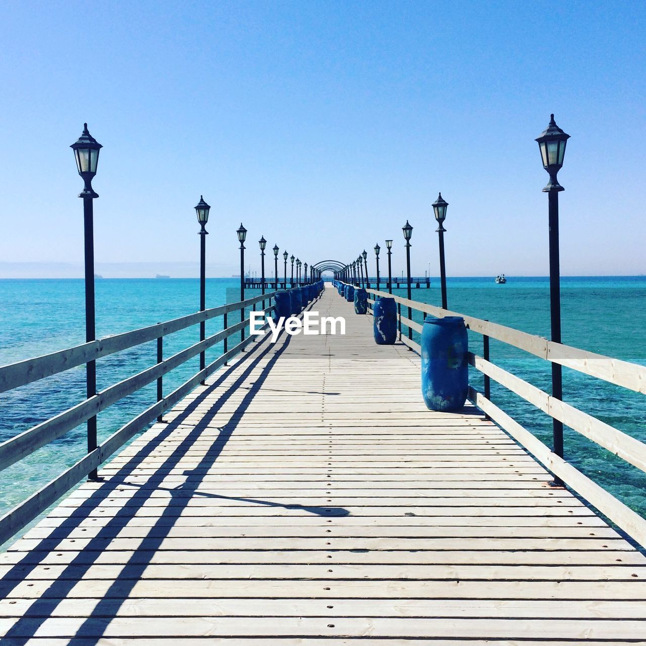 Pier on sea against blue sky