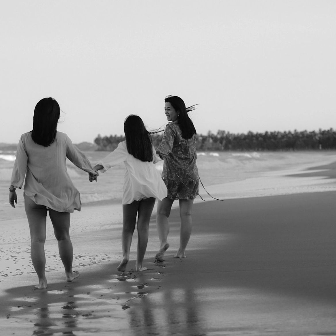 Rear view of women walking on beach