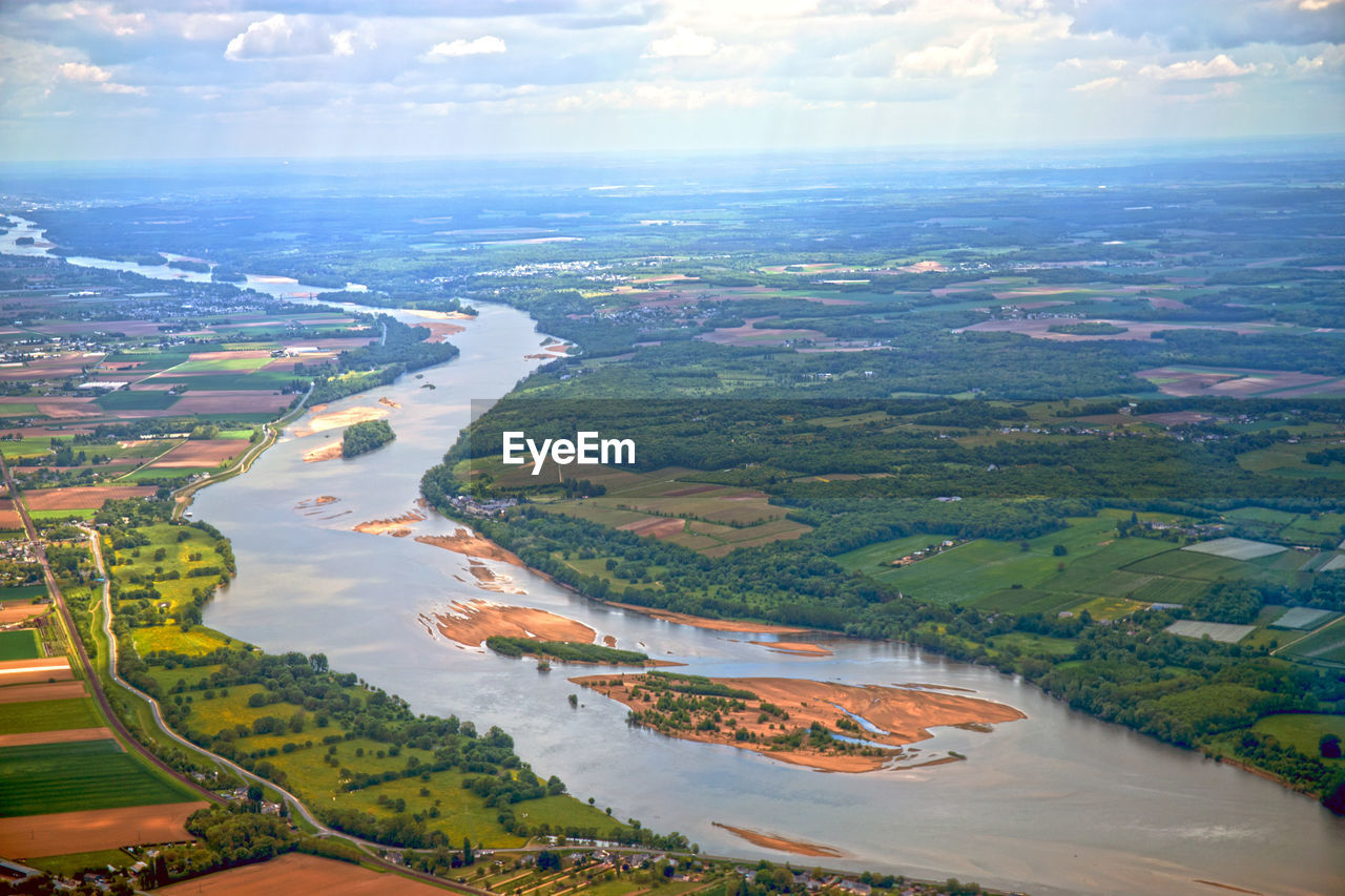 Aerial view of river amidst field against sky