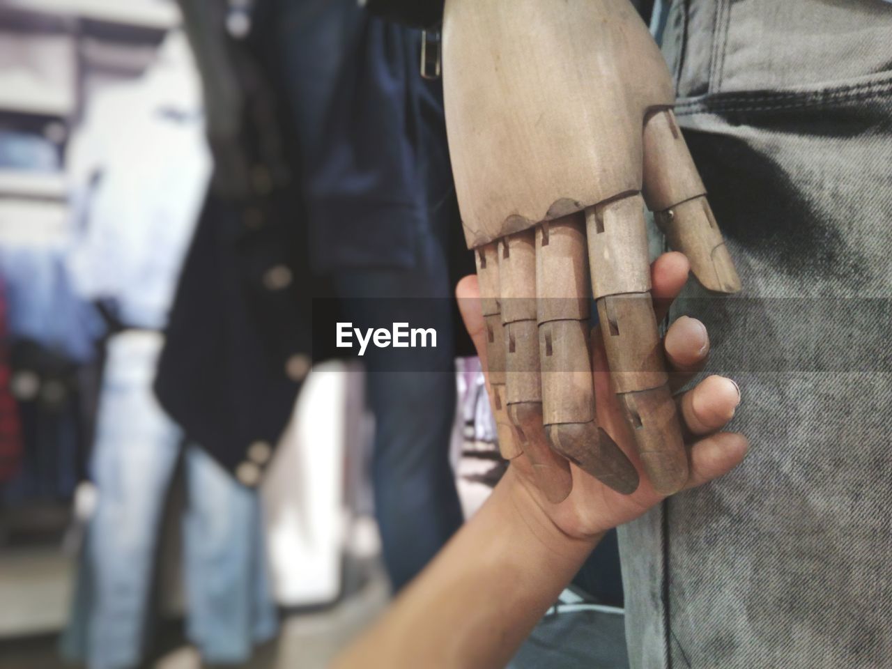 Cropped hand of person holding mannequin